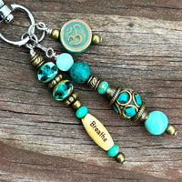 Handmade yoga-inspired charm with  word bead, Czech and gemstone accents, clipped to a purse. Amazonite and an Aum Bead in turquoise blue.