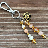 Golden Sun Charm
Handmade golden sun-themed charm with shimmering crystal and gemstone beads, perfect for adding warmth to bags or keychains.