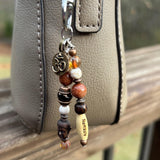 Elegant yoga-themed charm with Czech beads and a word bead, promoting mindfulness on everyday items, shown on purse