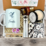 gift basket with a personalized simple flower coffee mug, engraved spoon, vibrant coaster, scented candle, artisan charm, and coffee treats for women’s holiday presents